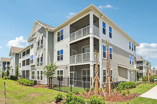 A large two-story apartment building with a balcony on the second floor.