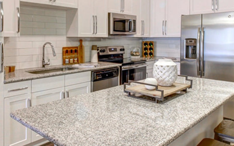 Kitchen area with large island with barstools and pendant lights