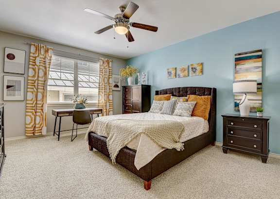 a bedroom with a bed and a ceiling fan