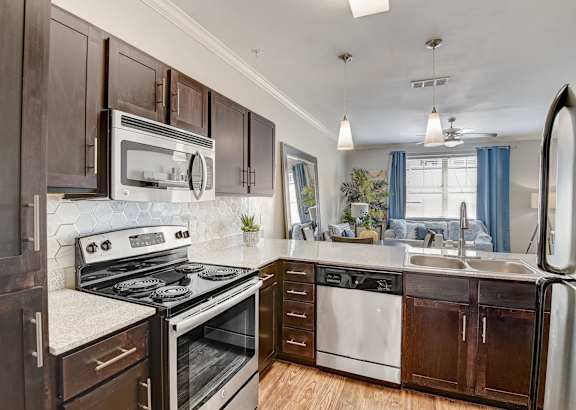 an updated kitchen with stainless steel appliances and wooden cabinets