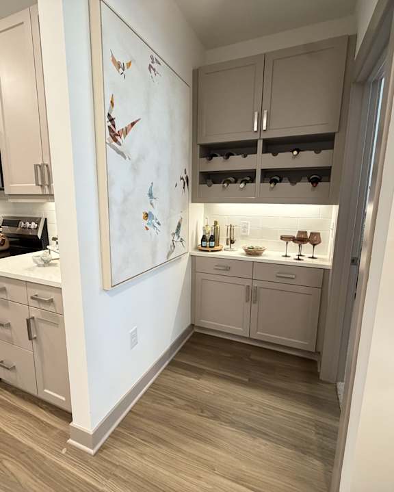 A kitchen with white cabinets and a fridge.