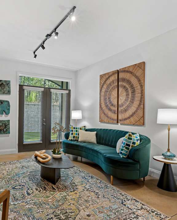 A bedroom with a large bed, a ceiling fan, and a painting on the wall.