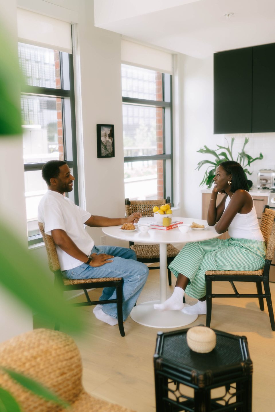 Two friends at a small dining table enjoying coffee & conversation