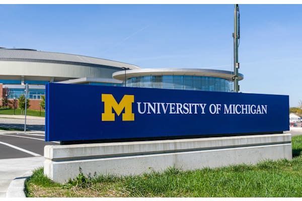 A large blue sign with a gold letter M on it that says University of Michigan at AVIA Lofts on Victors Way, Ann Arbor