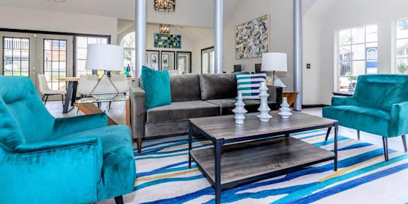 A living room with a blue rug and a blue chair.at The Davis Apartments, Huntsville, AL