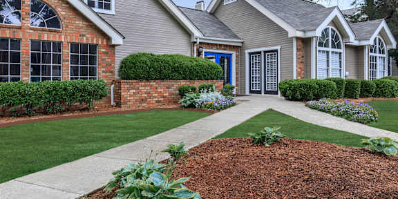 a home with a sidewalk and lawn in front of it at The Davis Apartments, Huntsville, AL 35816