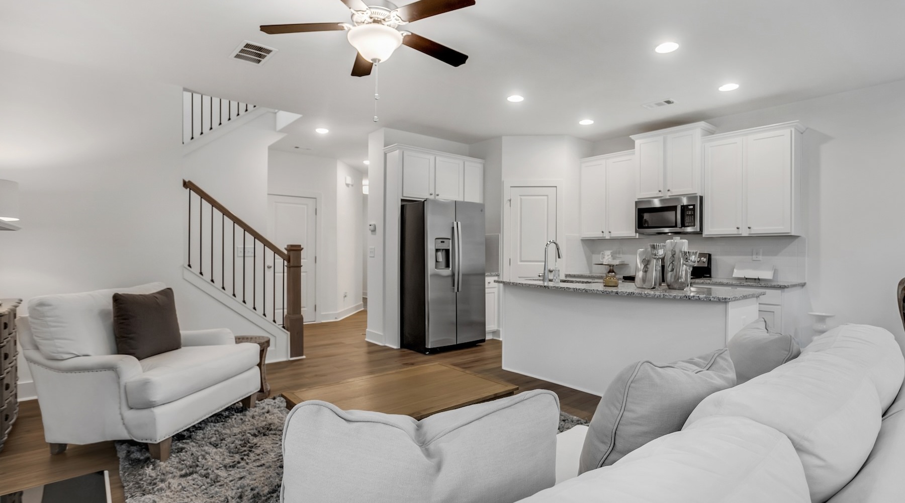 living room with ceiling fan couch and kitchen