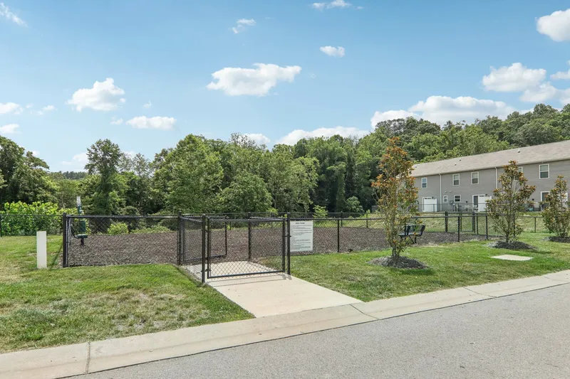 Outdoor fenced in dog park with benches in the daytime