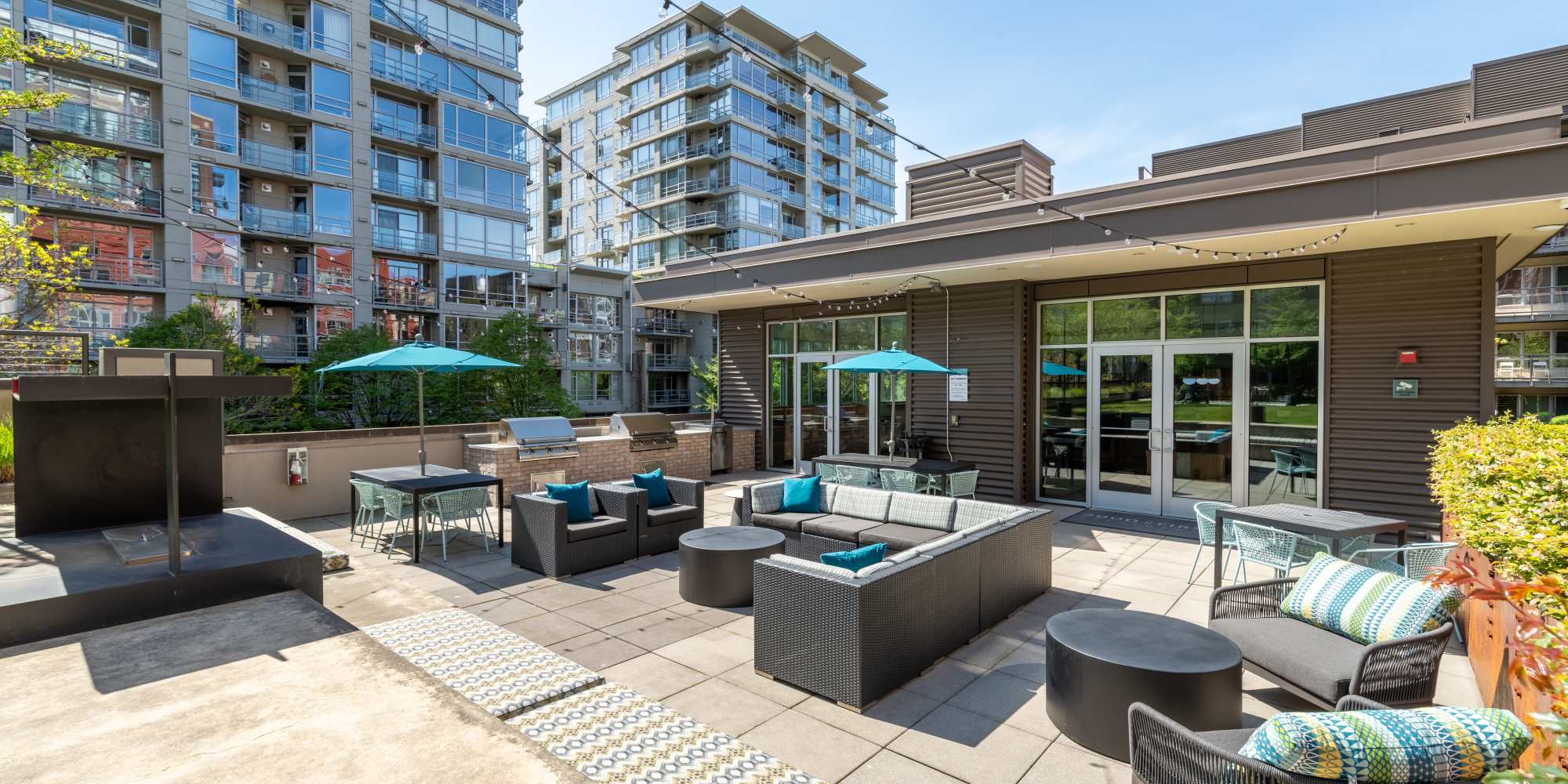 Outdoor BBQ grilling station with dining and seating areas at 2900 on First Apartments in Seattle, Washington