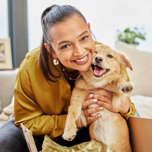 A woman holding a small dog at The Residences at The Gilmore in Gilbert, AZ