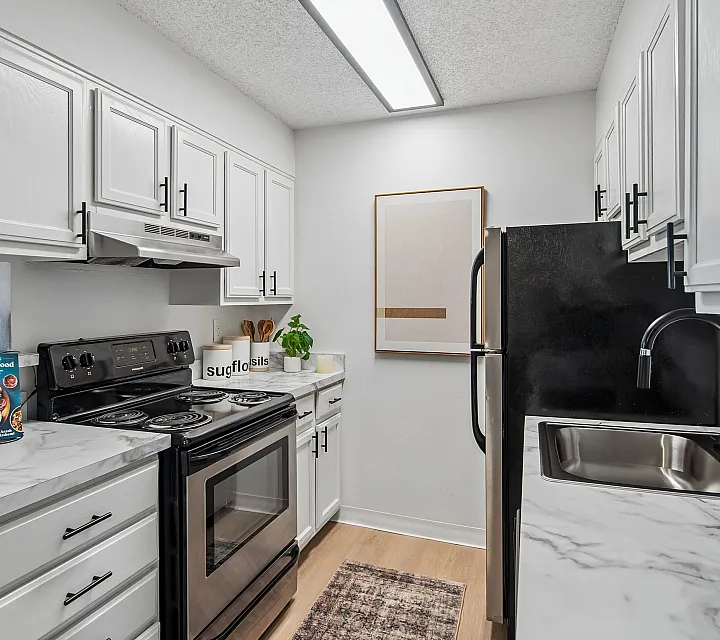 Modern kitchen featuring elegant white cabinetry, sleek stainless steel appliances, and stylish marble countertops.