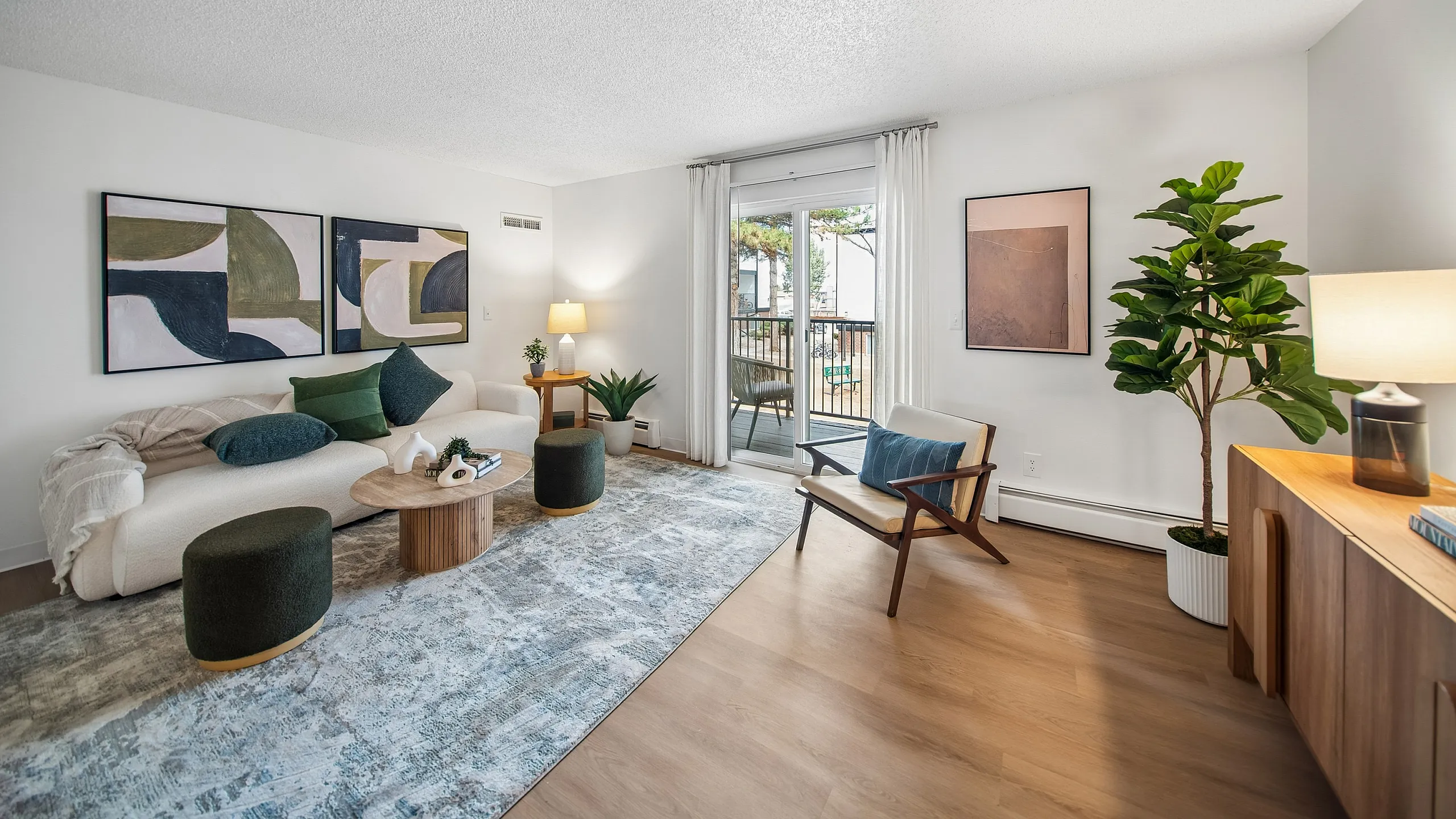 Bright and modern living room featuring elegant decor, a cozy sofa, lush plants, and access to a private balcony.