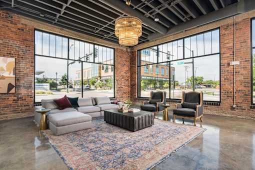 A living room with a grey sofa, a wooden coffee table, and a rug.