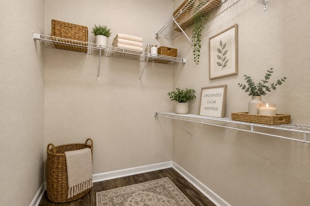 Organized closet with shelves, baskets, towels, and decor. Includes a framed print and a sign that s…