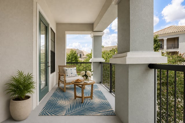 Balcony with a chair, table, and plant.