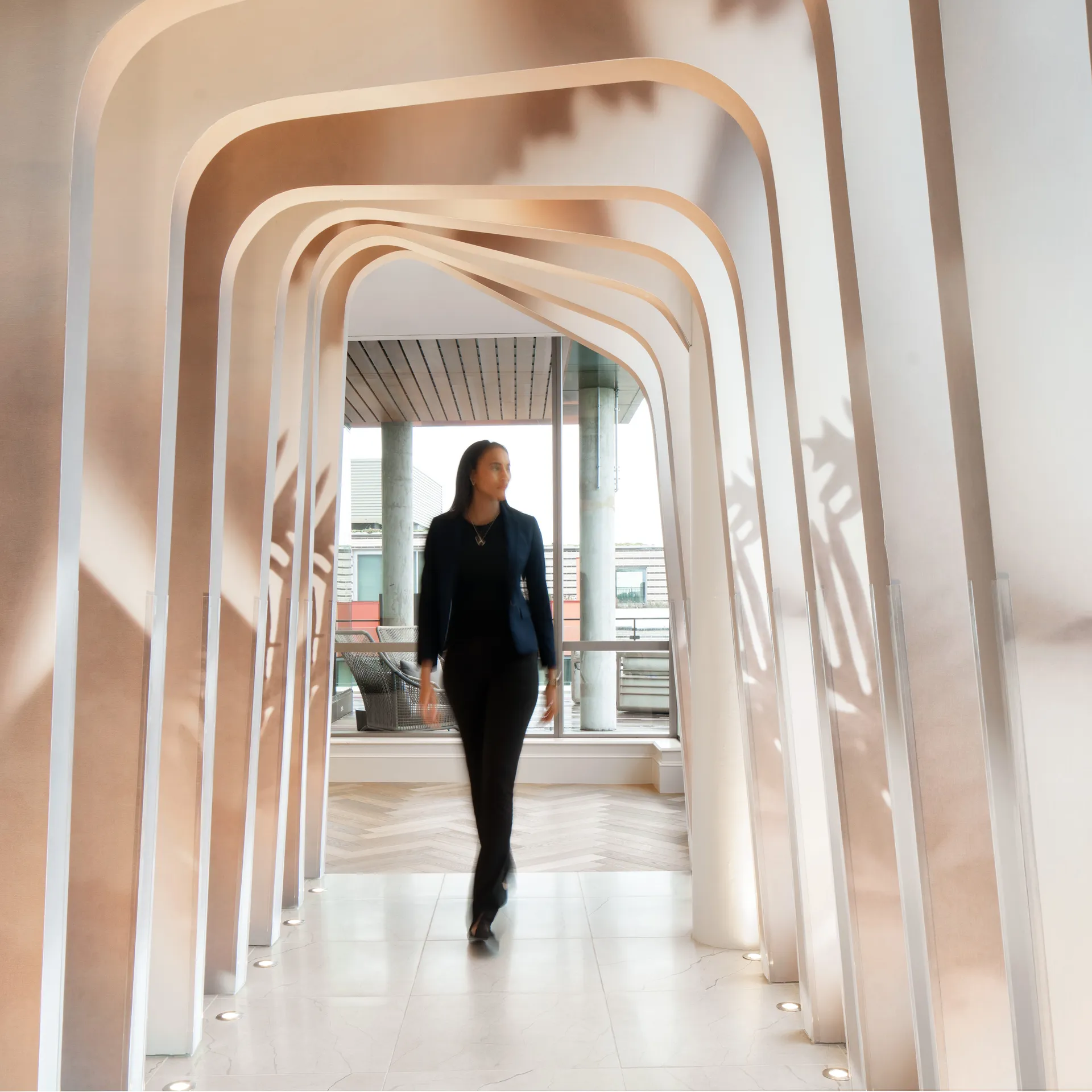 Person walking through a modern, curved passageway.