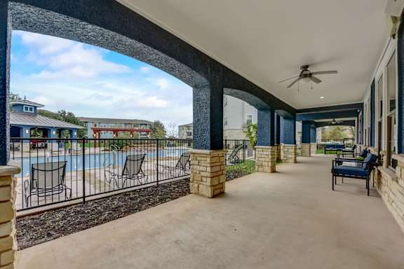 A patio with a pool and a black metal fence.