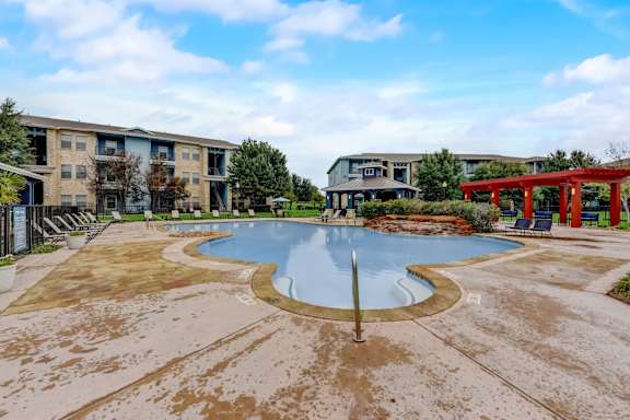 A swimming pool in front of apartment buildings.