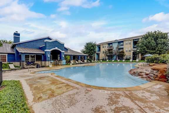 A blue building with a pool in front.