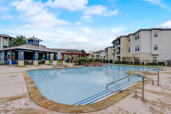 A swimming pool surrounded by a metal railing and a small building.