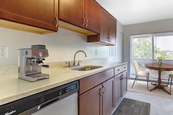 A modern kitchen with a stainless steel refrigerator and grey cabinets.