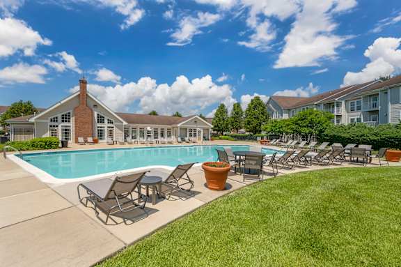 Pool With Relaxing Chairs at The Apartments at Wellington Trace, Frederick