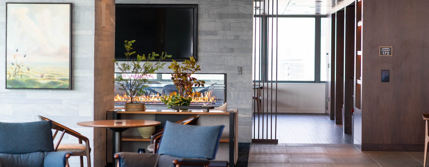 community area with a tv, large windows and ample seating options