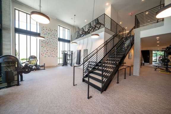 the lobby of a gym with a spiral staircase