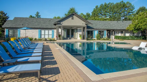 pool and furniture with apartment building on sunny day