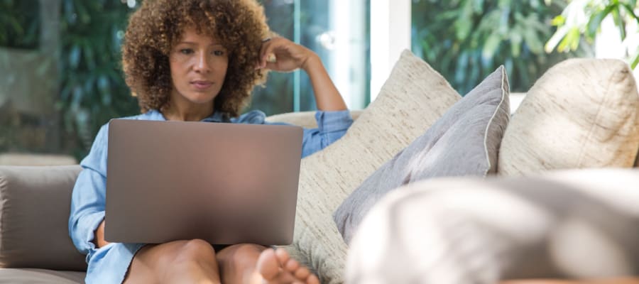 Resident using her laptop in her new apartment at Olea Beach Haven in Jacksonville, Florida