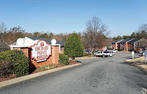 A sign for Orchard Pointe Townhomes is on the side of a road.