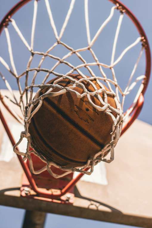 A basketball is about to go through the net.