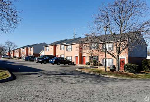A street view of a residential area with houses and cars.