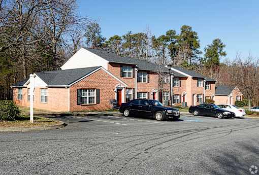 A black car is parked in front of a red brick building.