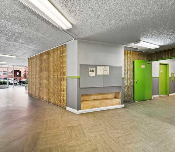 A long hallway with a green door at the end.