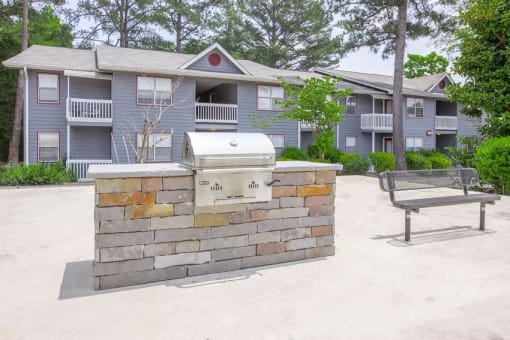 a picnic table and a grill in front of an apartment building