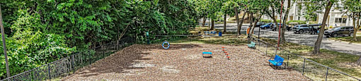 A tennis court surrounded by a fence and trees.
