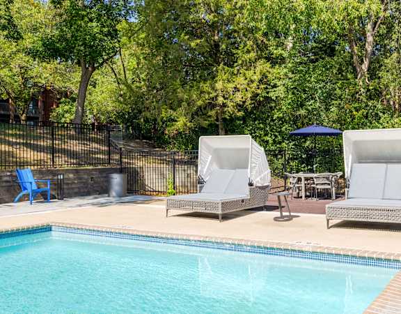Two sun loungers sit on the edge of a pool.