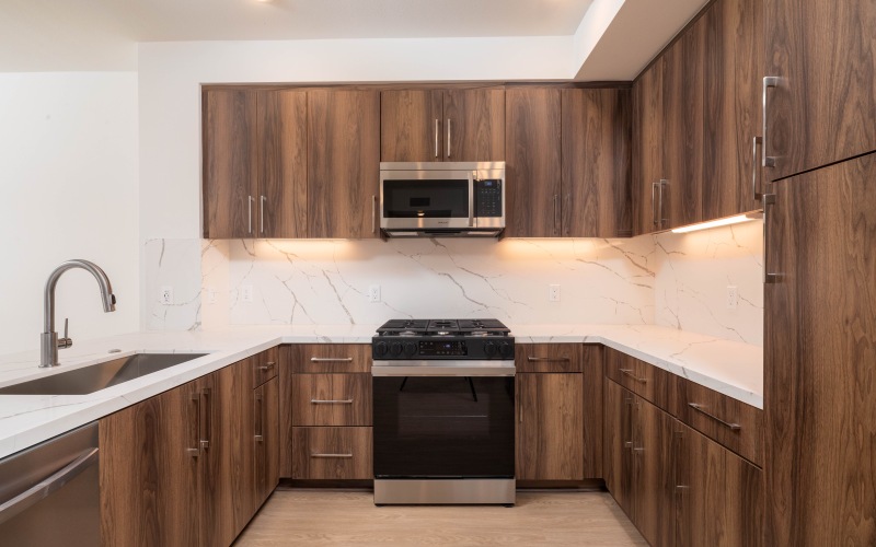 Kitchen with marble counters and backsplash at Lucia at Aviara luxury apartments in Carlsbad, CA.