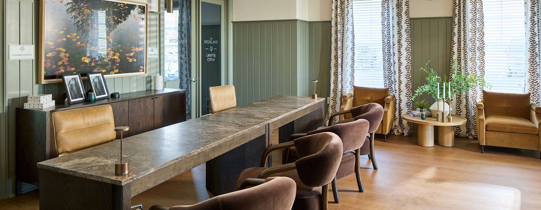 Modern leasing office with wood finishes, seating area, large windows, and a welcoming design for resident services