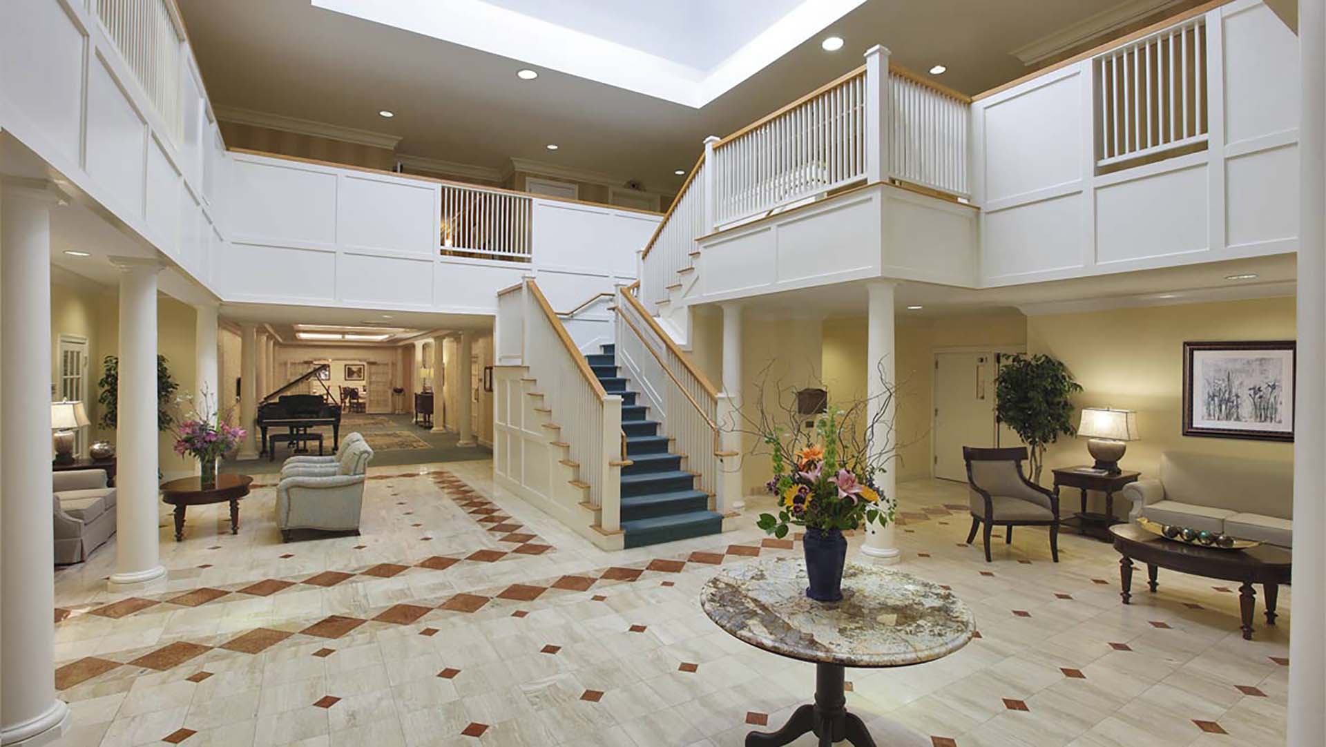 Entryway with grand piano and staircase leading up to the second floor