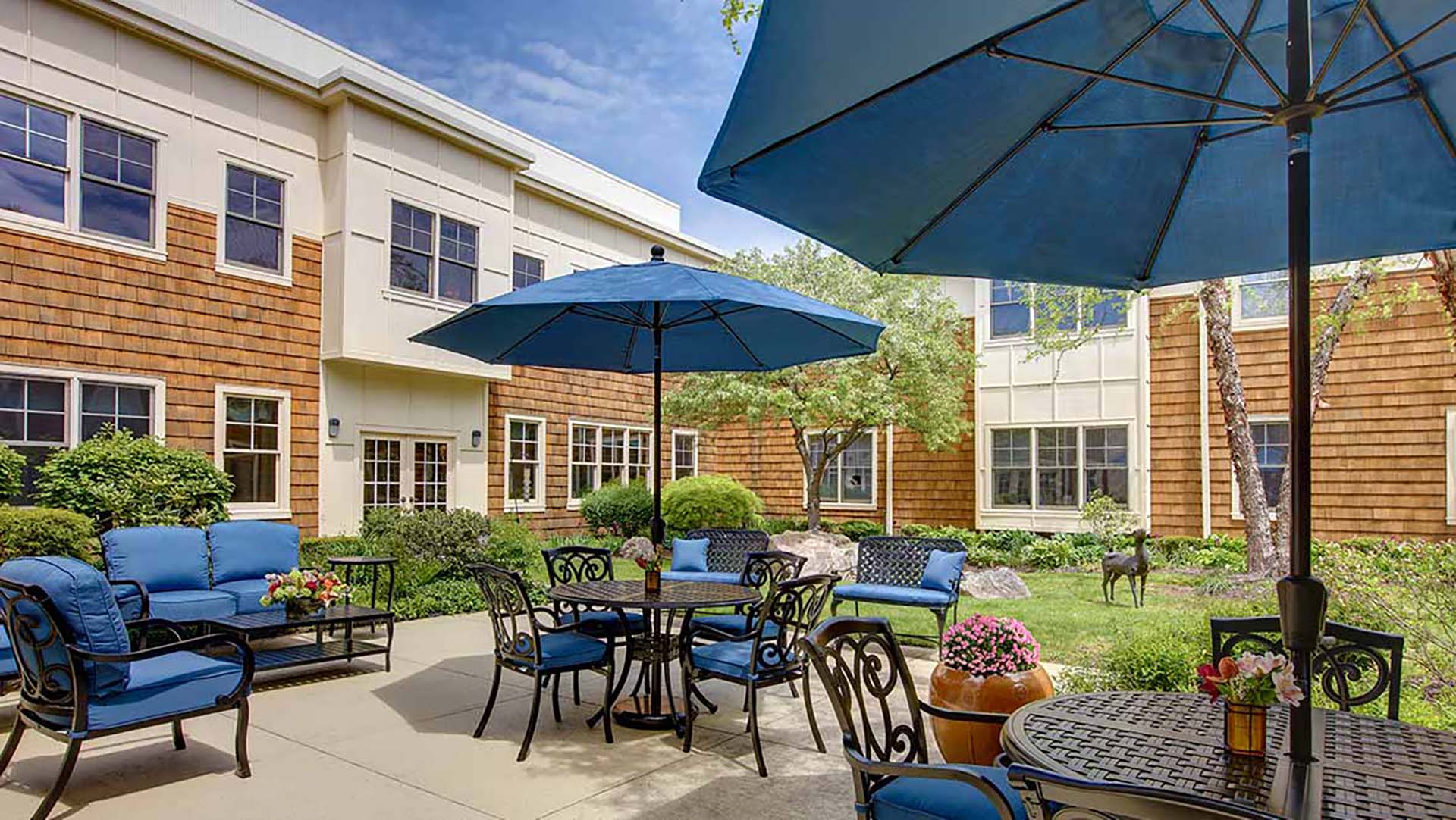 Outdoor tables with blue umbrellas located in the courtyard