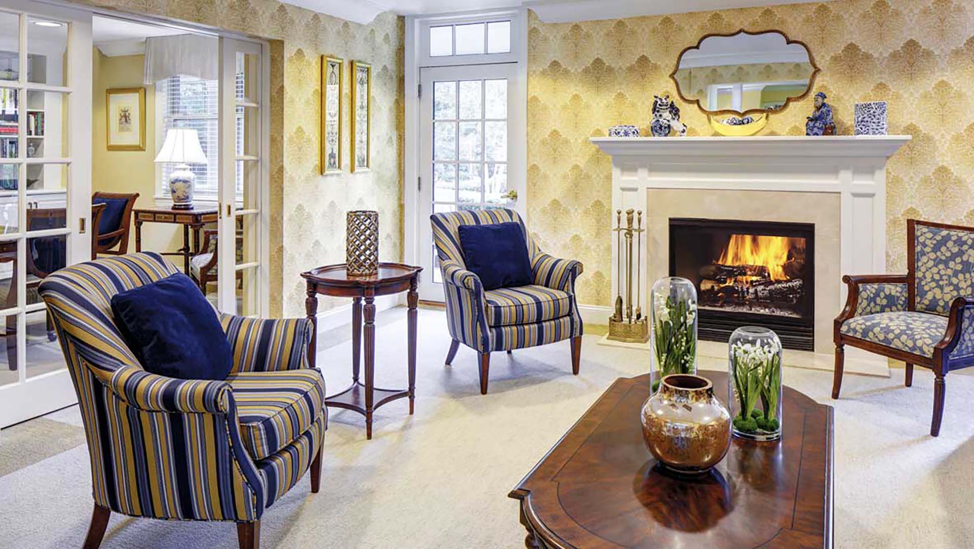 Living room area with yellow-and-blue cushioned chairs and a fireplace