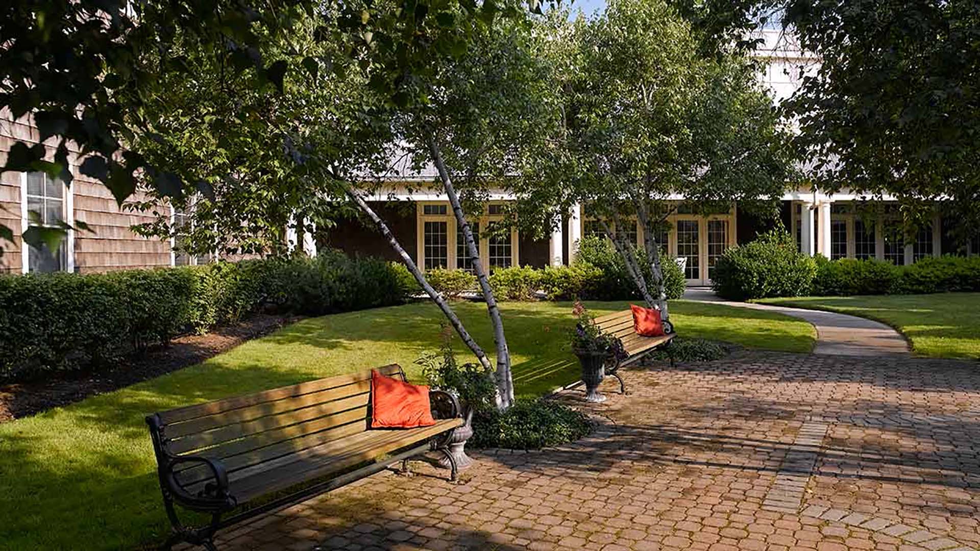 Outdoor cobblestone walking paths and benches shaded by trees