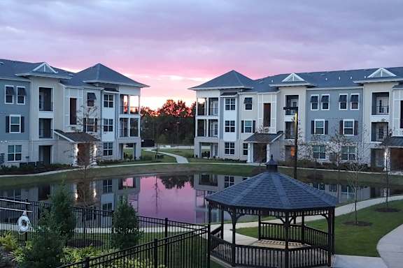 A gazebo is in front of apartment buildings.