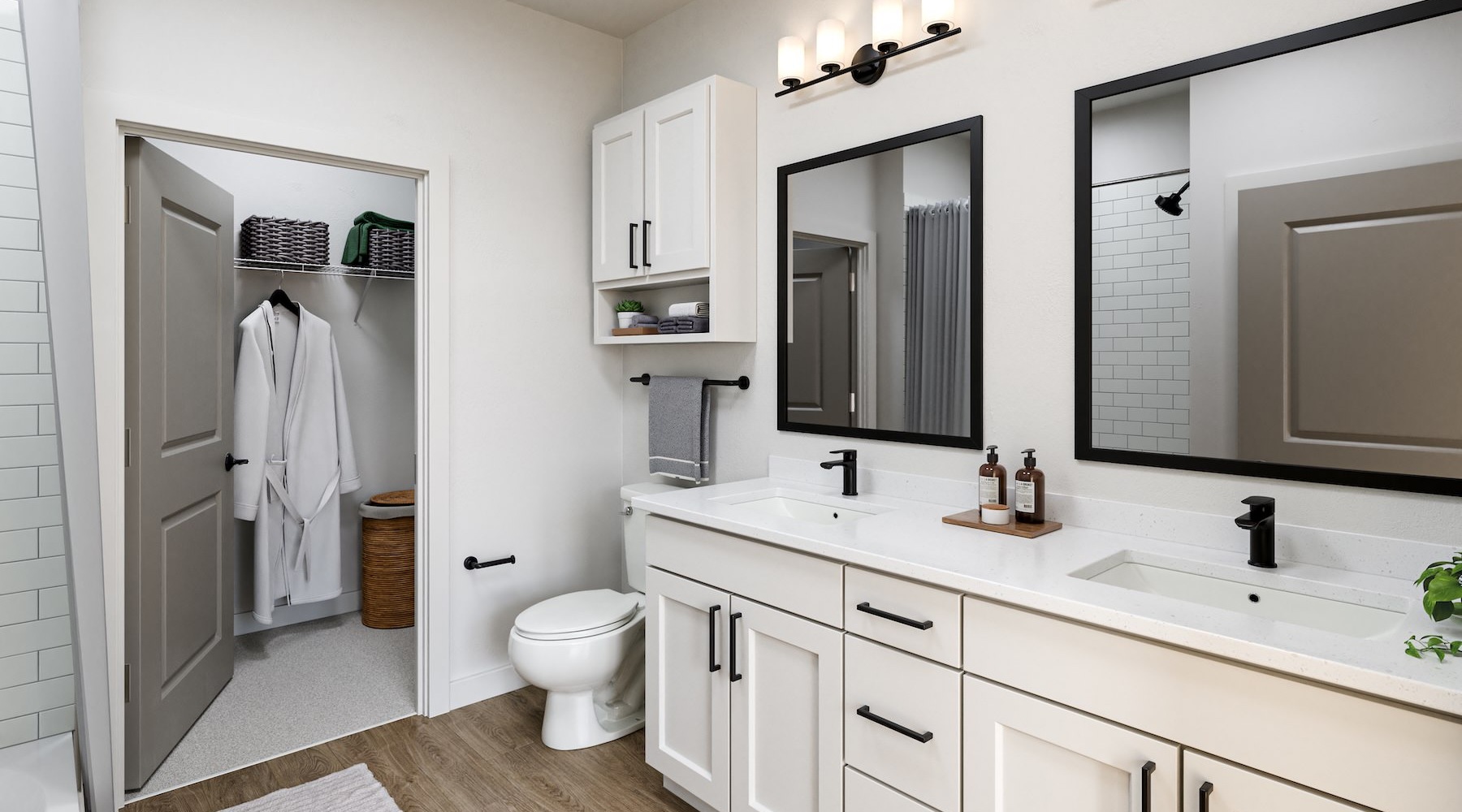 Spacious bathroom with two sinks on the vanity and a large closet that has a robe hanging up in the best apartments in Austin at Foxtail by Banyan.