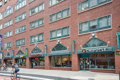 A Chipotle restaurant is located in a brick building.