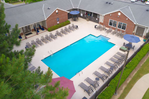 “Overhead view of the Lancaster Place community pool, showing clear blue water, lounge seating, and landscaped surroundings.
