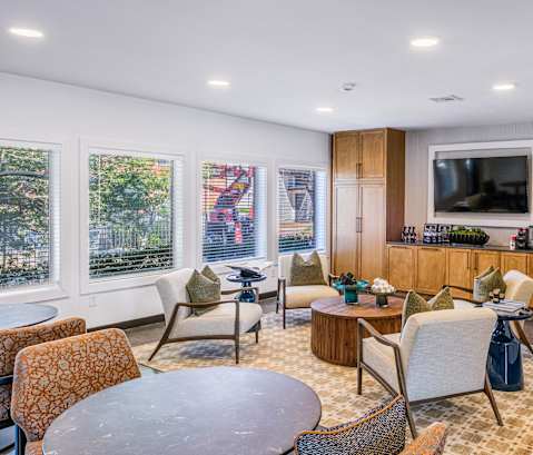 A modern living room with a television, a kitchen area, and a dining table. at Water Ridge Apartments , Irving, Texas