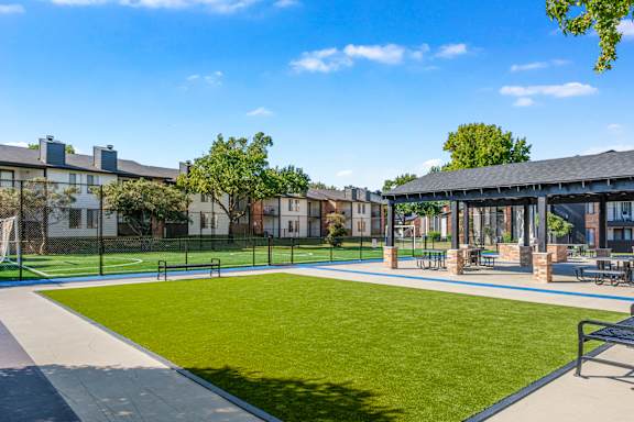 A sunny day at the park with a blue sky and a green lawn at Water Ridge Apartments , Texas, 75061